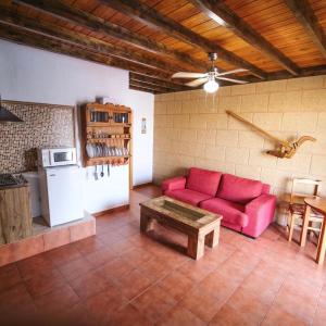 a living room with a red couch and a table at Club JM Lanzarote in Tabayesco