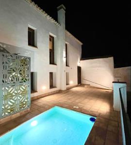 a swimming pool in front of a house at night at Balcón de la Moreria con alberca in Constantina