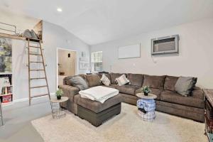 a living room with a brown couch and a ladder at Fox Cottage in Catonsville