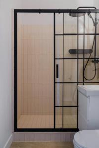 a glass shower door in a bathroom with a toilet at Warsaw Concierge Waszyngton in Warsaw