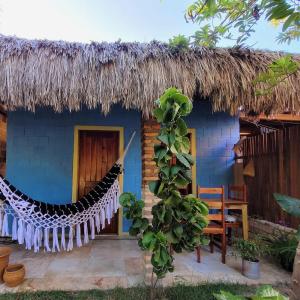 a blue house with a hammock in front of it at Vila Coqueiro - Moitas in Amontada