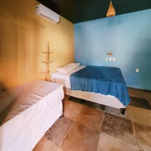 a bedroom with two beds and a blue wall at Vila Coqueiro - Moitas in Amontada