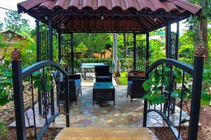 Casas del Toro Playa Flamingo في بلايا فلامنغو: شرفة مع طاولة وكراسي في حديقة