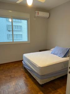 een slaapkamer met een bed en een raam bij Vista Maravilhosa Pitangueiras in Guarujá