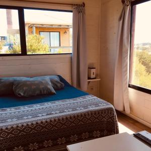 1 dormitorio con cama y ventana grande en Cabañas Utopía en Punta del Diablo