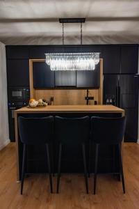 a kitchen with a bar with chairs and a chandelier at Moonlight Hill Point in Deal