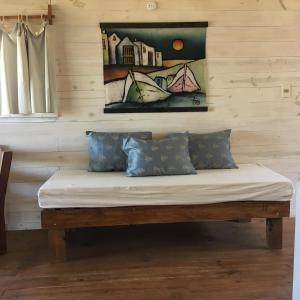 a bench in a room with a painting on the wall at Cabañas Utopía in Punta Del Diablo
