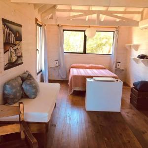 ein Schlafzimmer mit einem Bett und einem Tisch in einem Zimmer in der Unterkunft Cabañas Utopía in Punta Del Diablo