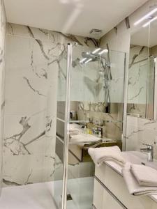 een badkamer met een douche, een wastafel en een spiegel bij Gold Europole-Gare in Grenoble