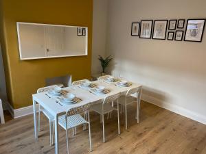 a dining room with a white table and chairs at Thornton - Stylish 3 bed terraced house with free parking in Darlington