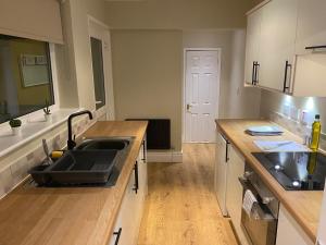 a kitchen with a sink and a counter at Thornton - Stylish 3 bed terraced house with free parking in Darlington