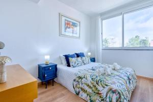 una camera da letto bianca con un letto e una finestra di Faro Center with AC & WiFi a Faro