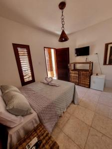 a bedroom with a bed and a television in it at Aloha Beach Guest House in Maragogi