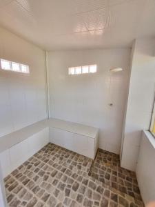 an empty room with white walls and a tile floor at Aloha Beach Guest House in Maragogi