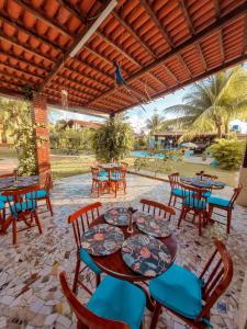 patio ze stołami i krzesłami oraz basenem w obiekcie Aloha Beach Guest House w mieście Maragogi