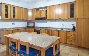 a kitchen with wooden cabinets and a table with chairs at Beautiful Apartment In Reggio Calabria With Wifi And 3 Bedrooms in Reggio di Calabria