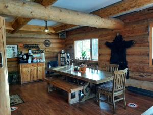 a dining room with a wooden table and chairs at Arctic Divide Lodge in Dease Lake