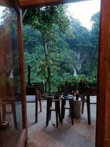 a patio with a table and chairs and a window at Espacio Pilam y cascada privada! in Xico