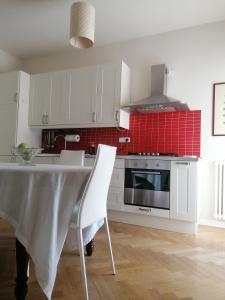 uma cozinha com uma mesa e uma parede de azulejos vermelhos em Letizia Apartment em Crotone