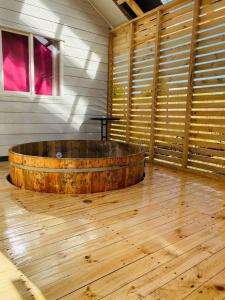 Habitación de madera con suelo y bañera de madera en Cabañas Agroturismo Pupelde, en Ancud