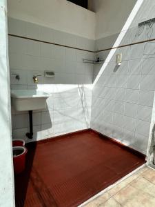 baño con lavabo y suelo rojo en Brisa del Valle en San Juan