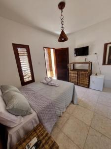 马拉戈日Aloha Beach Guest House的一间带大床和电视的卧室