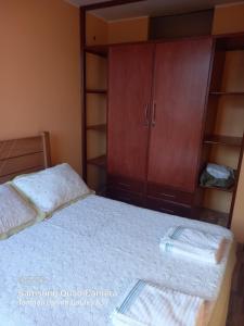 1 dormitorio con 1 cama y armario de madera en Huayqui, en Lima