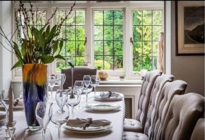 una sala da pranzo con tavolo e bicchieri da vino di Coach house a Woking
