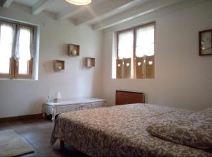 a bedroom with a bed and two windows at Les gîtes du petit mila in Labrit +15 photos