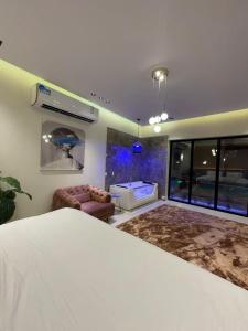 1 dormitorio con 1 cama y sala de estar con sofá en شاليه ريفو Revo chalet, en Al-Hasa