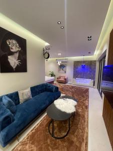 شاليه ريفو Revo chalet في الأحساء: غرفة معيشة مع أريكة زرقاء وحوض استحمام