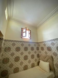 een kleine kamer met een bed en een raam bij Dar Haniya in Rabat