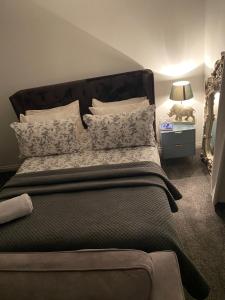 a bedroom with a large bed with pillows at Niv’s Home away from Home in Kempston