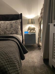 ein Schlafzimmer mit einem Bett und einer Lampe auf einem Nachttisch in der Unterkunft Niv’s Home away from Home in Kempston