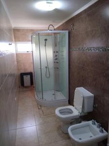 y baño con ducha, aseo y lavamanos. en Casona confortable y cálida con hermoso jardín en Río Gallegos