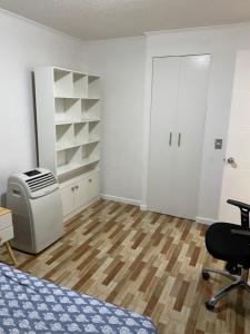 um quarto com uma cama, uma secretária e uma cadeira em Departamento Céntrico em Santiago