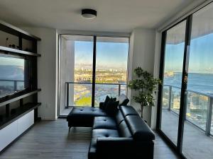 a living room with a leather couch and large windows at Beautiful downtown ocean view. in Miami