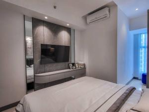 um quarto com uma cama e uma televisão de ecrã plano em Brand New - Luxury Modern Minimalist Design - 2BR em Lontar