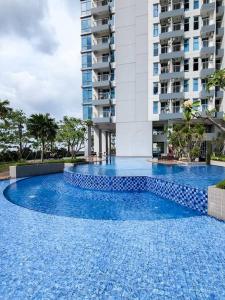 ein großer blauer Swimmingpool vor einem Gebäude in der Unterkunft Brand New - Luxury Modern Minimalist Design - 2BR in Lontar