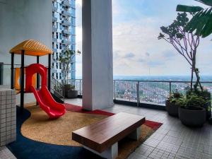 uma varanda com um escorrega vermelho e um banco em Brand New - Luxury Modern Minimalist Design - 2BR em Lontar