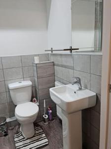 a bathroom with a toilet and a sink at Impeccable 4-Bed House Near Manchester City Centre in Manchester