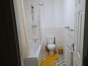 a bathroom with a shower and a toilet and a tub at Impeccable 4-Bed House Near Manchester City Centre in Manchester