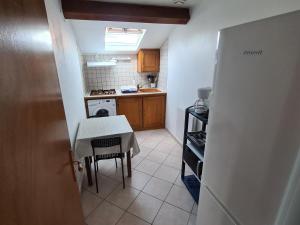 a small kitchen with a table and a table and a stove at Gîte Fontenoy-sur-Moselle, 2 pièces, 4 personnes - FR-1-584-175 in Fontenoy-sur-Moselle