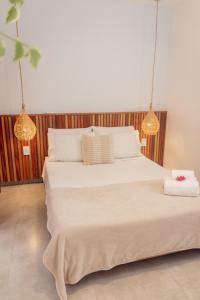 - une chambre avec un grand lit blanc et deux lumières dans l'établissement Apartamento Manay, à Jericoacoara