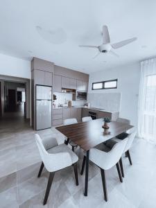a kitchen with a wooden table and white chairs at Nur Villa Sg Soi Musslimm Only in Kuantan