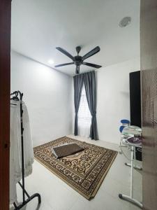 Habitación con ventilador de techo y alfombra. en Nur Villa Sg Soi en Kuantan