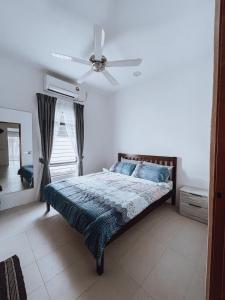 a bedroom with a bed with a ceiling fan at Nur Villa Sg Soi Musslimm Only in Kuantan