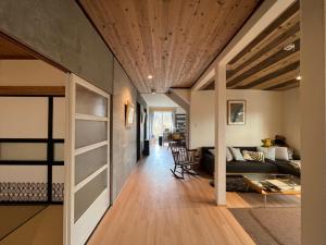 salon z drewnianym sufitem w obiekcie 民泊 47ハウス 家族でも楽しめる温泉付き一軒家 w mieście Shiraoi