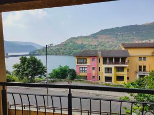 uma vista a partir de uma varanda com vista para uma massa de água em 2BHK Lake View Apartment em Lavasa