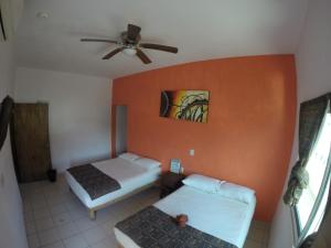 a bedroom with two beds and a ceiling fan at Kiramar los Peyotes in Rincon de Guayabitos